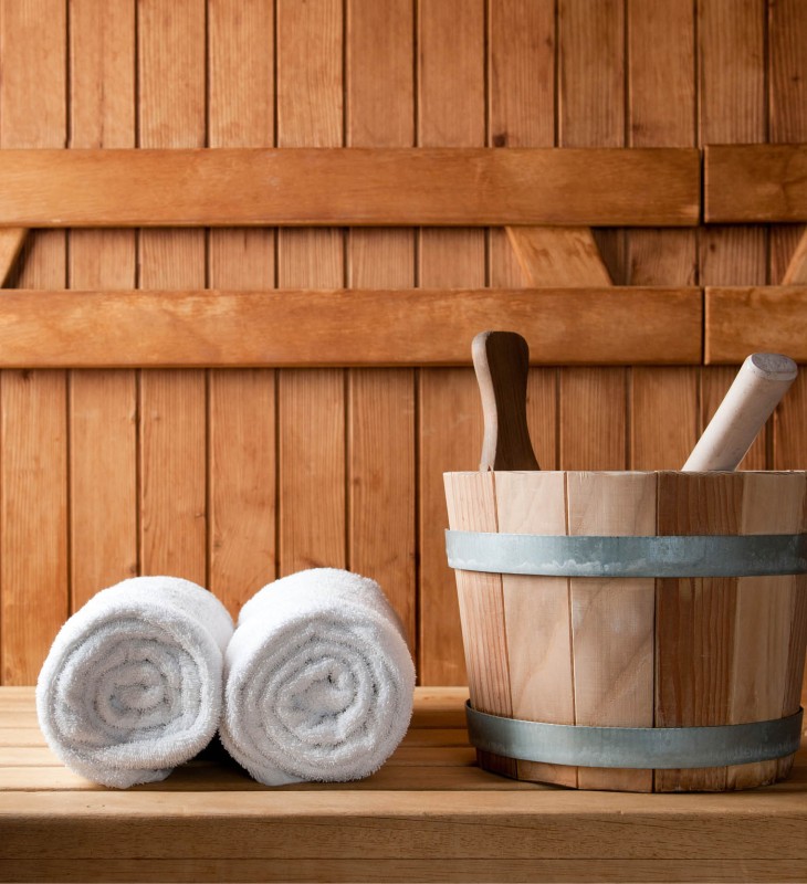 Handtücher und ein Wasserkorb sind in der Sauna ein Muss.