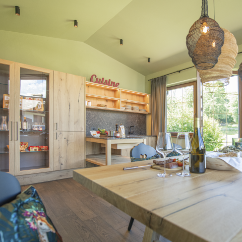 Das Bild zeigt die Gemeischaftsküche mit gedeckten Tisch. Im Hintergrund sieht man Südtiroler Produkte auf der Kochecke.