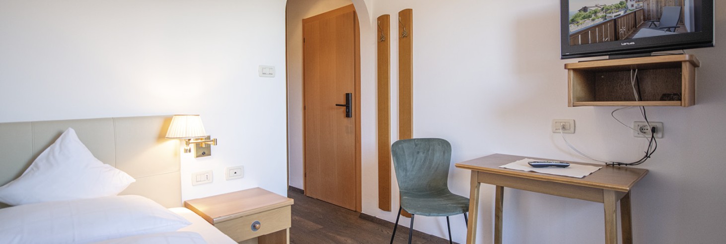 La camera single accogliente con letto singolo, scrivania e televisore.
