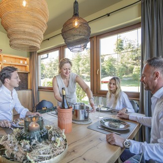 hubertus dolomites Völs am Schlern | Gemeinsam schmeckt's am besten: Entdecke unsere Gemeinschaftsküche Eine Familie am Esstisch in der Gemeinschaftsküche.