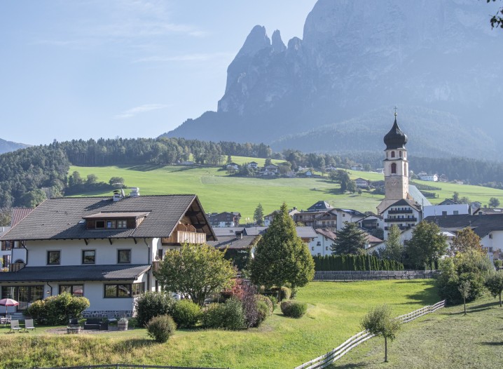 Das Hotel und im Hintergrund das Dorf Völs am Schlern und den Schlern.