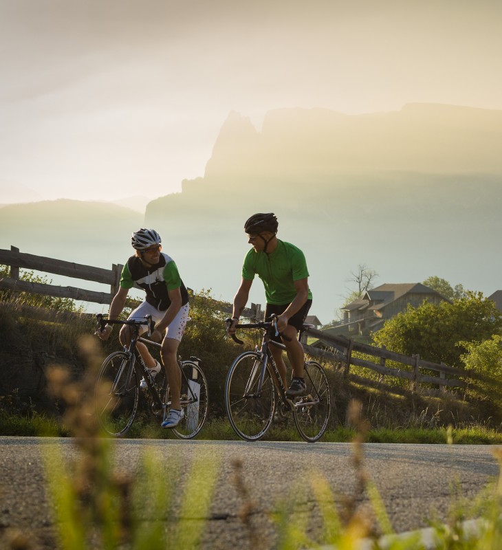 Zwei Radfahrer auf der Seiser Alm. Im Hintergrund sieht man den Schlern.
