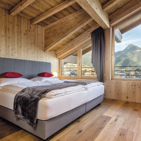 Ein Zimmer mit Bett und roten Kissen.