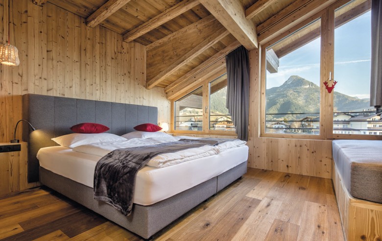 Ein Zimmer mit Bett und roten Kissen.