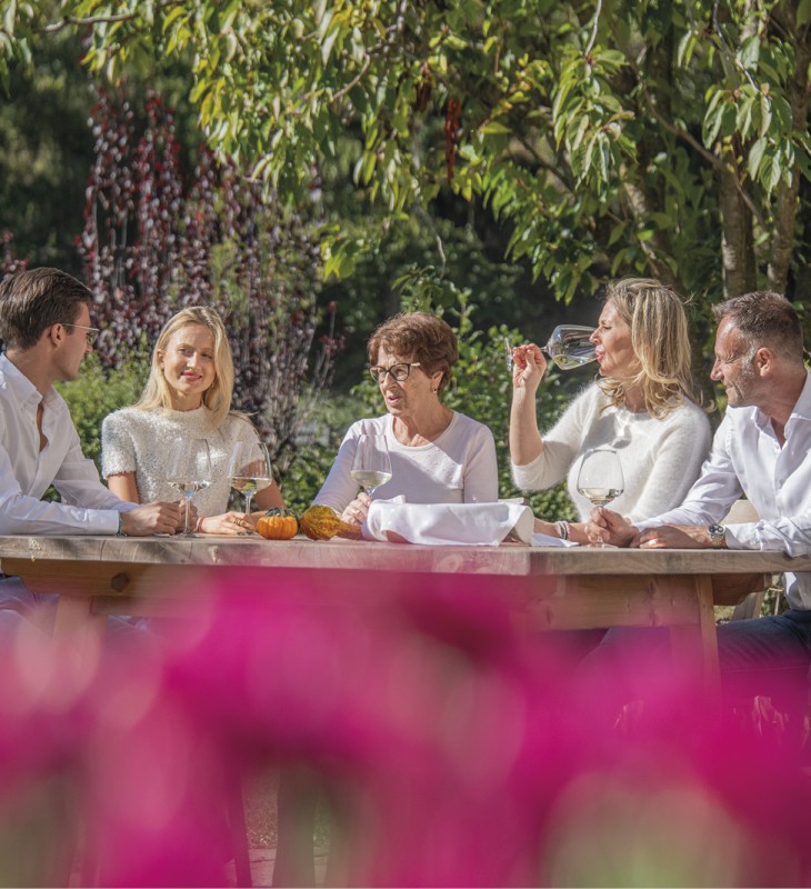 hubertus dolomites Völs am Schlern | Verbindungen knüpfen und Gespräche führen Familienauszeit im Garten. Sie genießen das schöne Wetter und trinken ein Glas Wein.